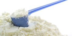 a blue and white toothbrush sticking out of a pile of powdered sugar on a white surface