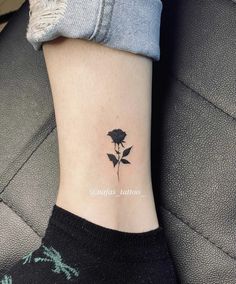 a small rose tattoo on the side of a woman's ankle, with one flower blooming