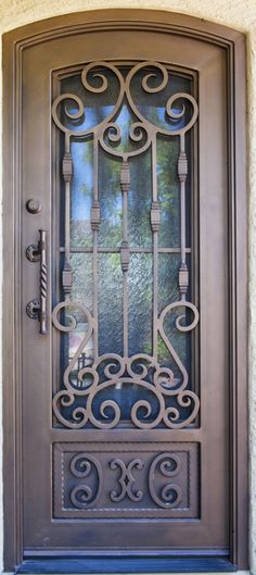 a brown door with wrought iron designs on the front and side doors, which have glass panels