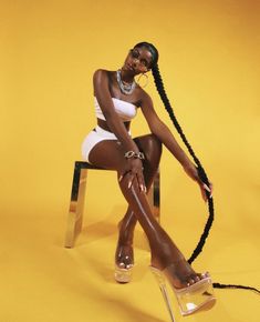 a woman sitting on top of a chair wearing high heels