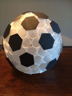 a paper mache soccer ball sitting on top of a wooden table