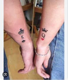 two people holding hands with tattoos on their arms and one is wearing a crown tattoo