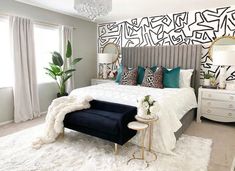 a bedroom with white and black decor on the walls, carpeted flooring and a large bed