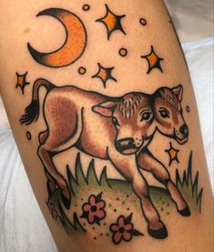 a tattoo with an image of a baby cow on it's leg and the moon in the background