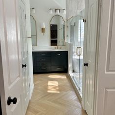 an empty bathroom with white walls and wood flooring is pictured in this image from the doorway