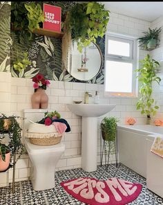 the bathroom is decorated in pink and white with lots of greenery on the walls