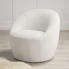 a white chair sitting on top of a wooden floor next to a sheepskin rug