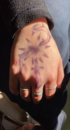 a person with a flower tattoo on their hand