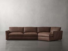 a brown leather couch sitting on top of a cement floor