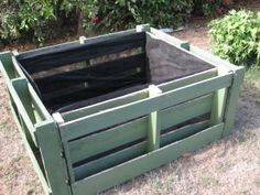 a large green wooden box sitting in the grass