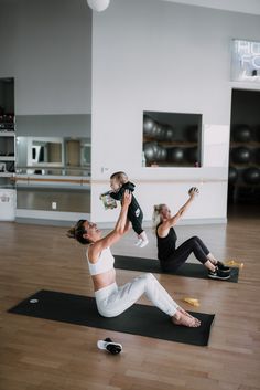 two women and a baby are doing yoga