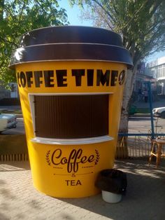 a yellow coffee machine sitting on the side of a road