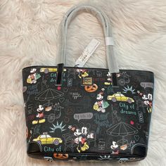 New, Disney, Minnie And Mickey New York City Tote Dooney And Bourke. Sold In Disney Japan 10 1/2” H X 12” W X 4 1/2” D Handle Drop: 10 1/4” Interior Zip Pocket Two Interior Slip Pockets Cell Phone Pocket Interior Key Hook Reinforced Corners On Base Goldtone Hardware Lined Metal Feet ”Dooney & Bourke Since 1975” Embossed Leather Label Inside ”Dooney & Bourke 1975” Embossed Metal Label On Front Black Disney Bags With Character Print, Multicolor Disney Bag With Mickey Mouse Design, Multicolor Disney Mickey Mouse Bag, Minnie And Mickey, Disney Japan, Embossed Metal, Disney Addict, Key Hook, Leather Label