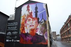 a mural on the side of a building with a woman's face painted on it