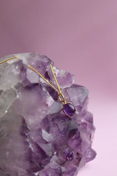 . Gemstone: Amethyst  . Gemstone Properties" Amethyst is known for its soothing properties that help relieve stress and promote calmness. . Finish: 14K Gold Plating Experience the beauty and elegance of our Amethyst Necklace, a perfect representation of your February birthstone. This dainty necklace features a stunning Amethyst pendant that is delicately handcrafted and plated with 14K gold for an exquisite finish. The pendant's unique cut highlights the gemstone's natural hues, creating a breat Spiritual Purple Pendant Necklace, Purple Gemstone Pendant Jewelry, Amethyst Round Pendant Jewelry With Natural Stones, Amethyst Round Pendant With Natural Stones, Amethyst Jewelry With Natural Stones In Round Pendant, Amethyst Stone Necklaces For Gifts, Amethyst Stone Necklace For Gift, Lavender Stone Jewelry Gift, Oval Amethyst Birthstone Necklaces