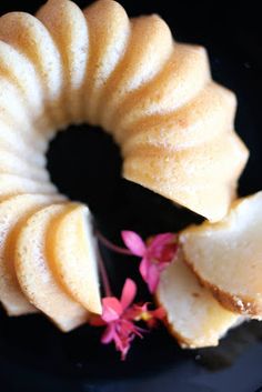 a bundt cake on a black plate with pink flowers