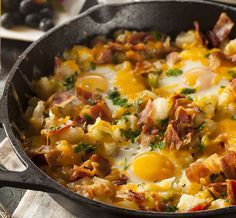 a skillet with eggs, bacon and cheese in it