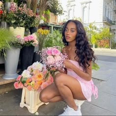 a woman sitting on a bench with flowers in front of her