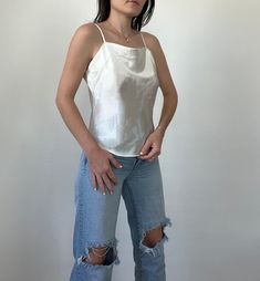 Adorable white-colored swaure neck camisole from the 90s, great to dress up or down. In good vintage condition. Measurements taken while item is laid flat. Measurements: bust: 19" length: 21" Tag size: Small Fabric: Polyester Model is 5'6 with a waist 26" and hips 36" FOLLOW US ON INSTAGRAM @theweathereddaisy FOR RELEASE DATES + STORY SALES! SHOP OUR WEBSITE theweathereddaisy.com FOR EVEN MORE EXCLUSIVE APPAREL. Silky Camisole, White Square, Womens Blouses, The 90s, Square Neck, Womens Clothing Tops, White Vintage, Dates, Blouses For Women