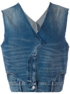 a denim vest with buttons on the front and back, worn by a woman in blue jeans