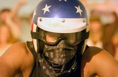 a man wearing a motorcycle helmet and bandana with stars on it's face