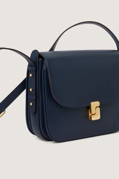 Prussian blue glazed leather bag - Shoulder, or cross-body bag - Adjustable leather handle, maximum length 135 cm - Large front flap with golden monogrammed clasp - One zipped inside pocket - Golden metal details - Height 19 cm, width 24 cm, depth 5 cm Headphone Accessories, Prussian Blue, Iconic Bags, Fragrance Gift Set, Ring Pendant Necklace, Wholesale Shoes, Reusable Bags, Laptop Accessories, Beauty Bag