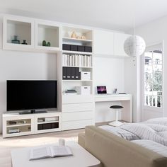 a living room filled with furniture and a flat screen tv on top of a white entertainment center