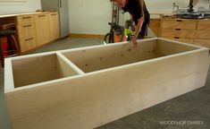 a woman is working on an unfinished cabinet