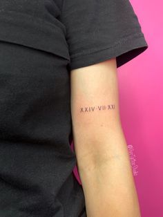 a woman's arm with roman numerals tattooed on the left side of her arm