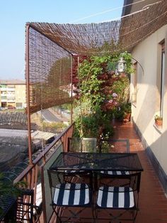 an outdoor table and chairs on a balcony