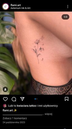 the back of a woman's stomach with a flower tattoo on her left side