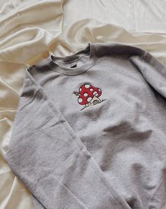 "Mushroom House Embroidered Sweatshirt! Embroidered on a cotton/polyester blend crewneck sweatshirt! This design is simple and minimalistic perfect for the cottage core look! -Embroidery design measures 5\" x 4\" -See product pictures for shirt sizing chart. -All sweatshirts are handmade on an embroidery machine so there may be slight differences, but we only sell the sweatshirts that meet our high-quality standards. -To maintain the quality of your sweatshirt and the embroidery design make sure Mushroom House Embroidery, Cotton Fall Sweatshirt With Mushroom Print, Cotton Sweatshirt With Mushroom Print, Cotton Crew Neck Sweatshirt With Mushroom Print, Cotton Sweatshirt With Mushroom Print For Fall, Casual Crew Neck Sweatshirt With Mushroom Print, Casual Fall Sweatshirt With Mushroom Print, Winter Cotton Tops With Mushroom Print, Cotton Long Sleeve Sweatshirt With Mushroom Print