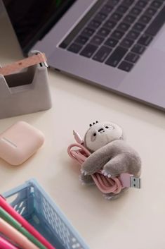 a small stuffed animal sitting on top of a desk next to an open laptop computer