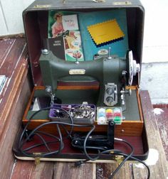 an old sewing machine sitting inside of a suitcase