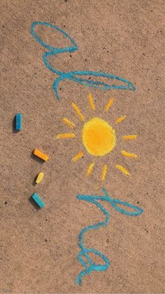 some crayons are laying on the ground and one is drawn with colored pencils