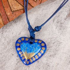 Radiant with golden accents a heart centers this delightful necklace. Edith Orozco works in papier mache giving the pendant a rich blue color and painting it by hand. It poses on dark blue cords that are adjustable in length. A coat of lacquer protects it and adds shine. Blue Heart, Deep Sea, A Heart, Washer Necklace, Jewelry Necklace Pendant, Necklace Lengths, Dark Blue, Blue Color, Jewelry Necklaces