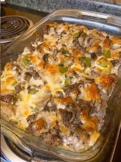 a casserole dish with meat, cheese and vegetables in it on top of a stove