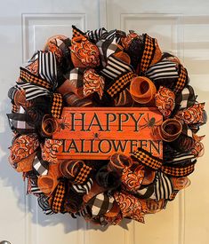 a happy halloween wreath with orange and black ribbons hanging on the front door for decoration