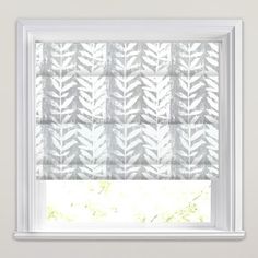 a window with a white roman blind in front of it and an image of leaves on the blinds