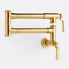 the brass faucet is attached to the wall and has two handles on each side