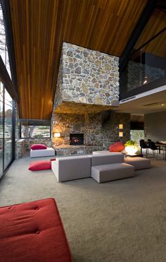 a living room with couches, tables and a fireplace in the middle of it