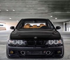 the front end of a black car parked in a parking garage