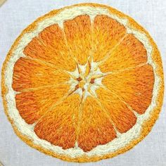 an orange is shown in the middle of embroidery