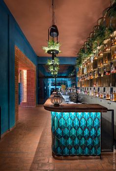 a bar with many bottles on the shelves and lights hanging from the ceiling above it