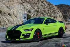 a lime green mustang parked in front of a mountain