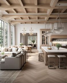 a living room filled with furniture next to a kitchen and dining room table in front of large windows