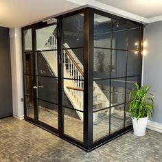 an empty room with glass doors and a potted plant in the corner on the floor