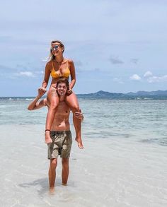 a man carrying a woman on his back in the ocean