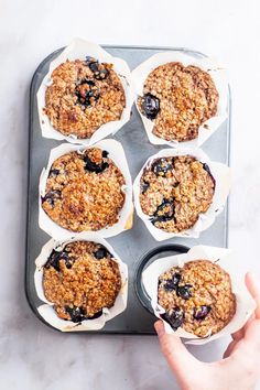 muffins with blueberries and oatmeal in paper cups on a baking tray