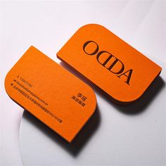 two orange business cards sitting on top of each other